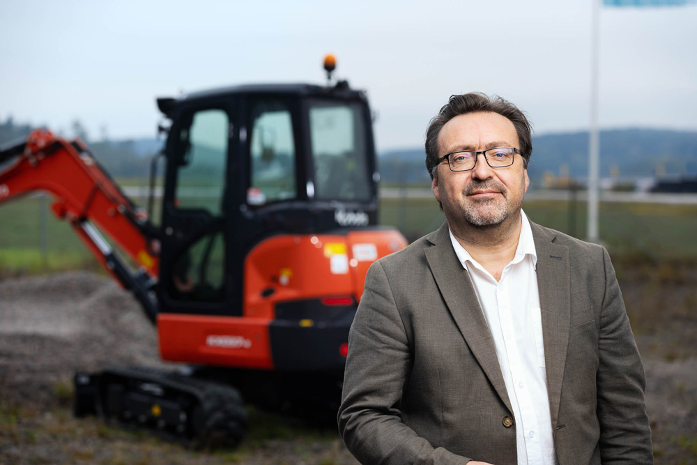 omas Andreasson, VD på Maskino, står framför en Kubota-maskin vid huvudkontoret i Munkedal.